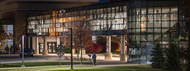 Helmke Library and the skybridge fully lit up at night.